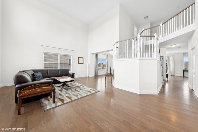 living room with hardwood / wood-style floors and a towering ceiling