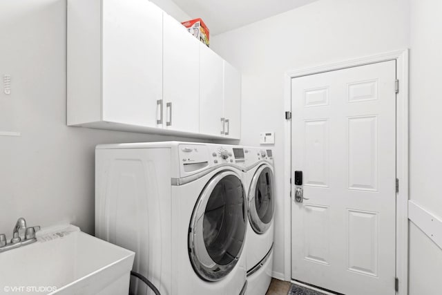 washroom featuring cabinets, sink, and separate washer and dryer