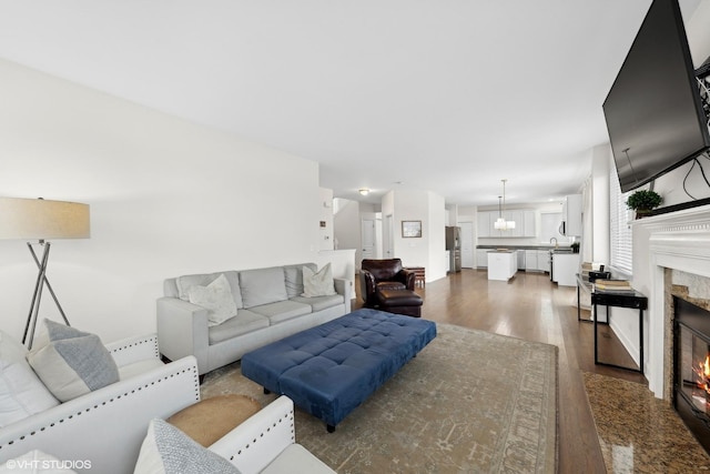 living room featuring a premium fireplace, dark hardwood / wood-style flooring, and sink