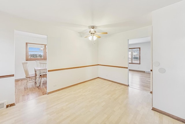 spare room with ceiling fan and light wood-type flooring