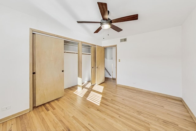 unfurnished bedroom with two closets, ceiling fan, and light hardwood / wood-style floors