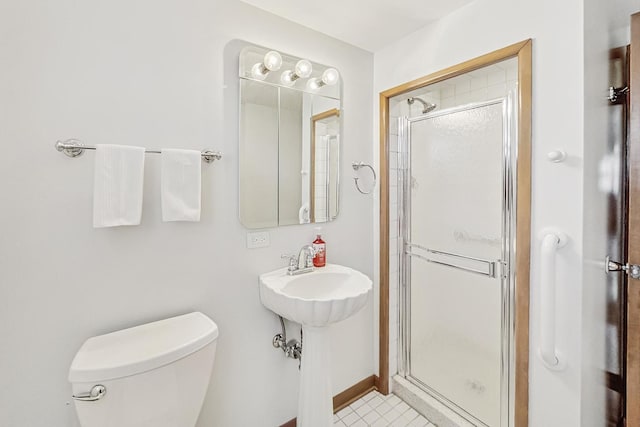 bathroom featuring toilet and a shower with door