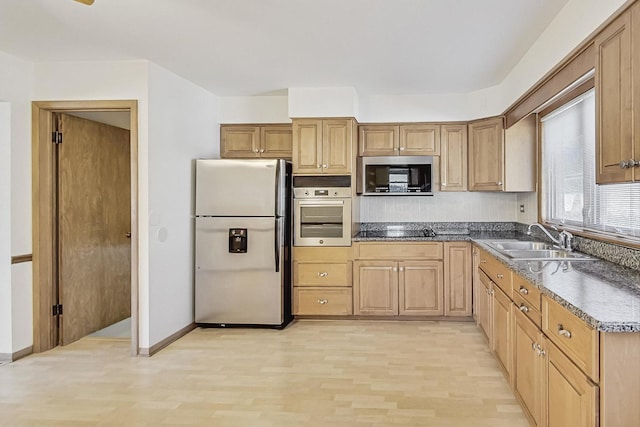 kitchen featuring appliances with stainless steel finishes, sink, and light hardwood / wood-style floors