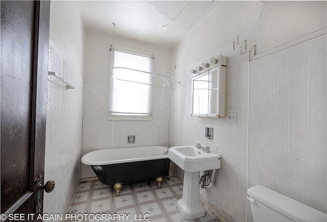 full bath with a bath, toilet, tile walls, and tile patterned floors