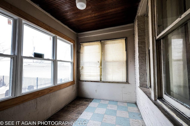 unfurnished sunroom with wooden ceiling and a wealth of natural light