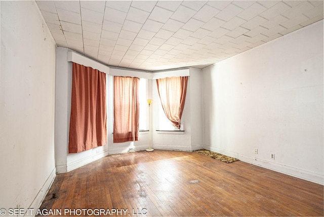 unfurnished room featuring baseboards and hardwood / wood-style floors