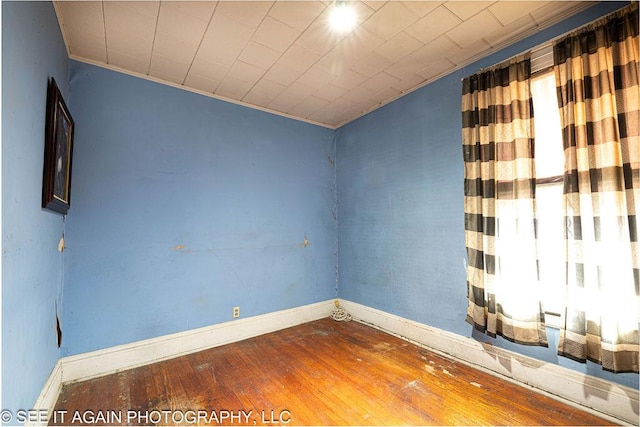 unfurnished room with wood-type flooring and baseboards