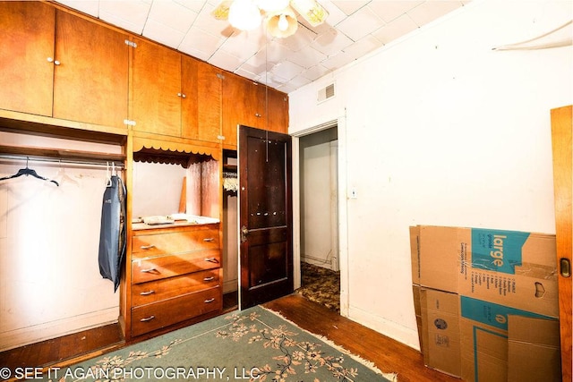 unfurnished bedroom with dark wood-style floors, baseboards, and visible vents