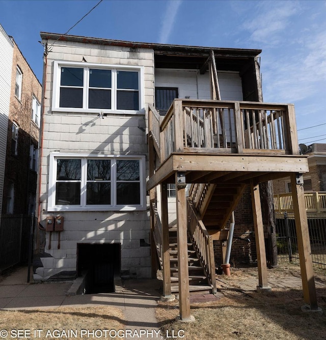 back of house featuring stairs, a deck, and fence