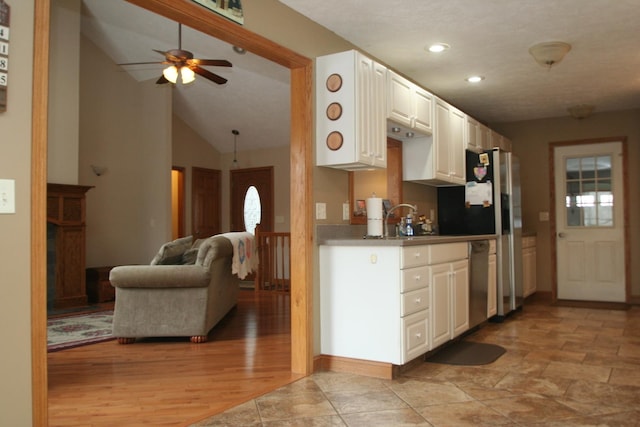 kitchen with stainless steel appliances, lofted ceiling, white cabinetry, ceiling fan, and sink