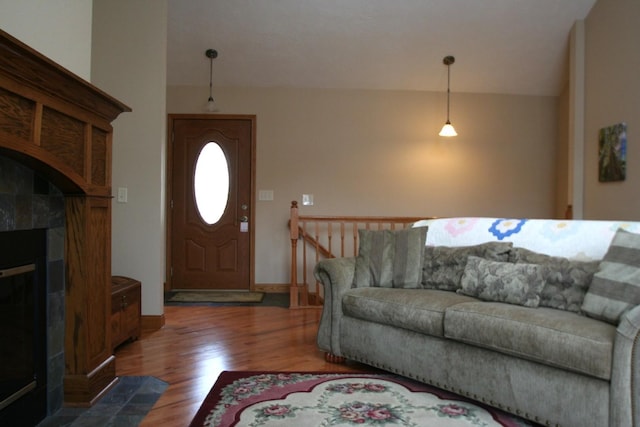 living room with hardwood / wood-style flooring and a tile fireplace