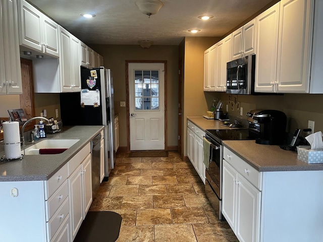 kitchen with stainless steel appliances, white cabinetry, and sink