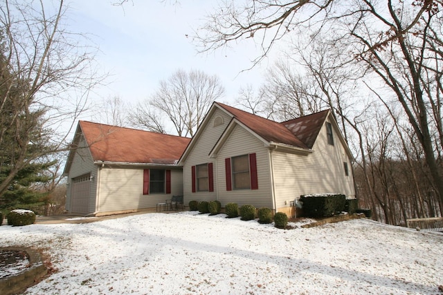 view of snowy exterior with a garage