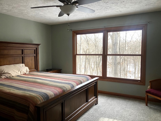 carpeted bedroom with a textured ceiling and ceiling fan