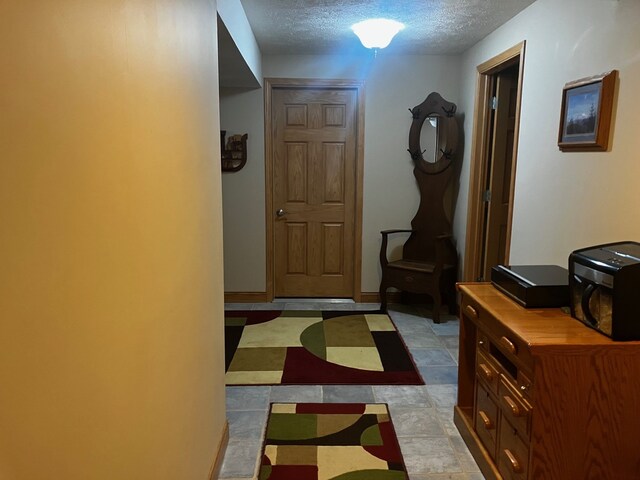 hall featuring a textured ceiling