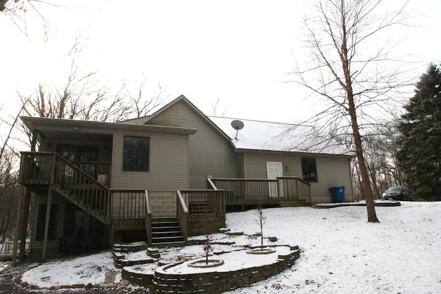 snow covered house featuring a deck