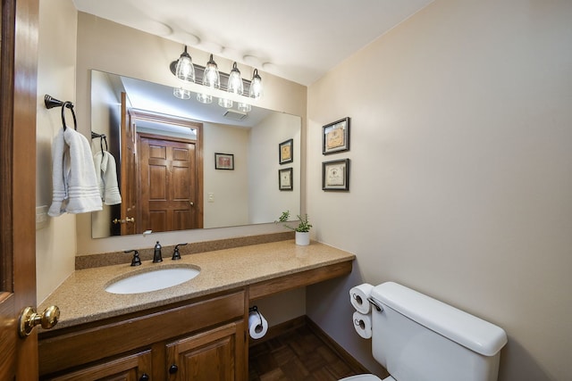 bathroom with vanity, parquet flooring, and toilet