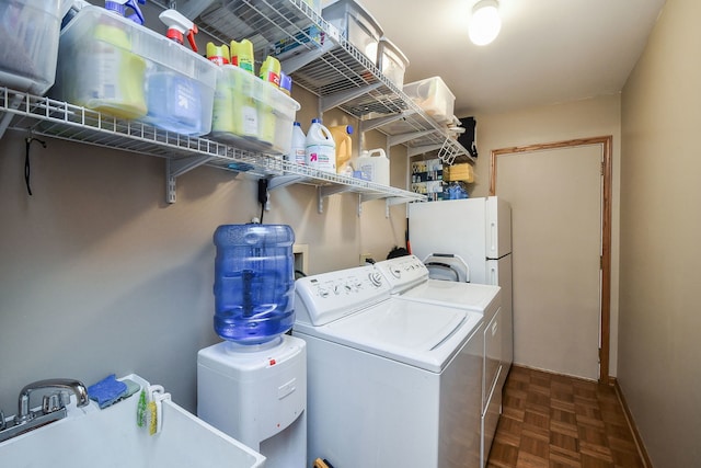 clothes washing area featuring sink, dark parquet floors, and independent washer and dryer