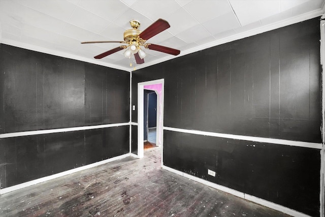 empty room featuring ceiling fan, crown molding, and hardwood / wood-style floors