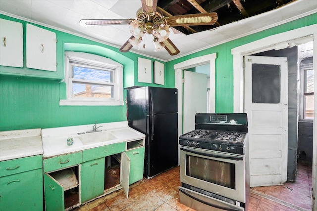 kitchen with light parquet floors, ceiling fan, black fridge, ornamental molding, and gas range