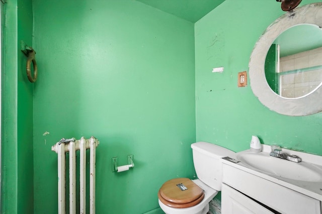 bathroom featuring toilet, vanity, and radiator