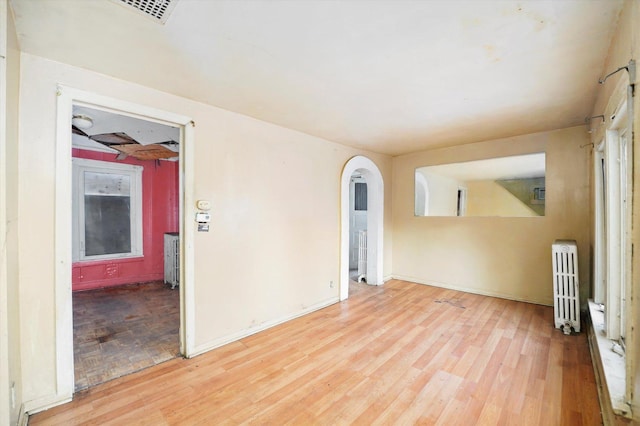 unfurnished room with radiator and light hardwood / wood-style flooring