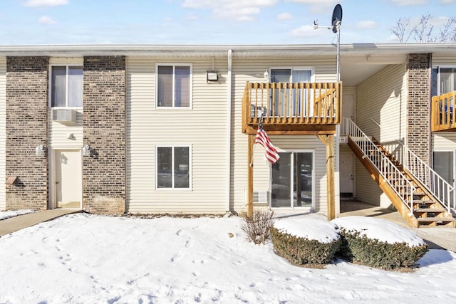 snow covered back of property featuring a balcony