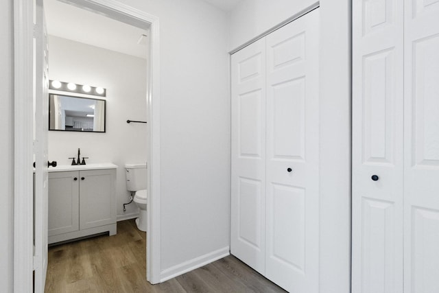 bathroom with toilet, hardwood / wood-style flooring, and vanity