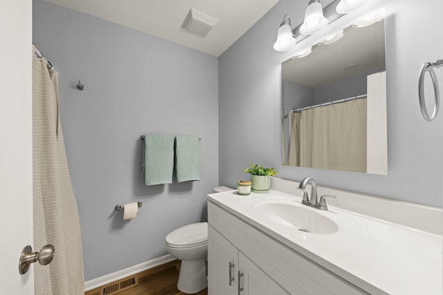 bathroom featuring vanity, wood-type flooring, and toilet