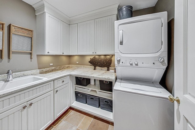 laundry area with sink, cabinets, and stacked washer and dryer