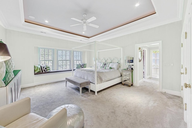 carpeted bedroom with ornamental molding, ceiling fan, and a raised ceiling