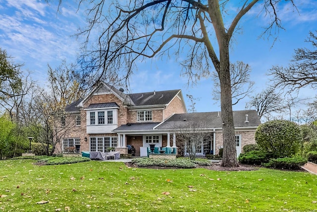 back of property featuring a patio and a lawn