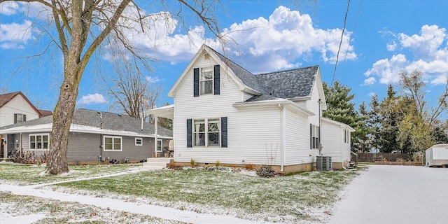 view of front of house featuring central AC and a front yard