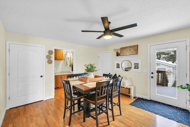 dining room with ceiling fan, a textured ceiling, and light wood-type flooring