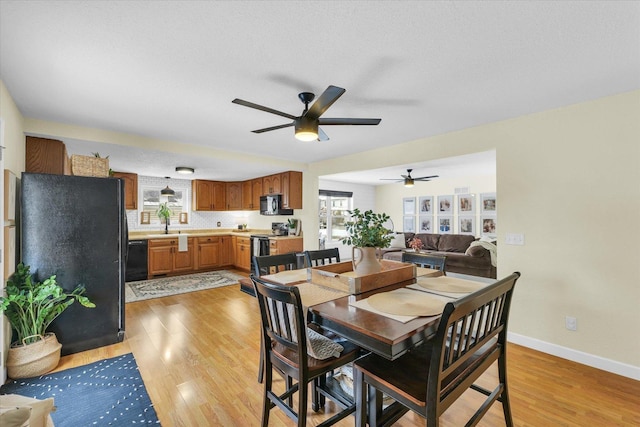 dining area with ceiling fan, light hardwood / wood-style flooring, and a textured ceiling