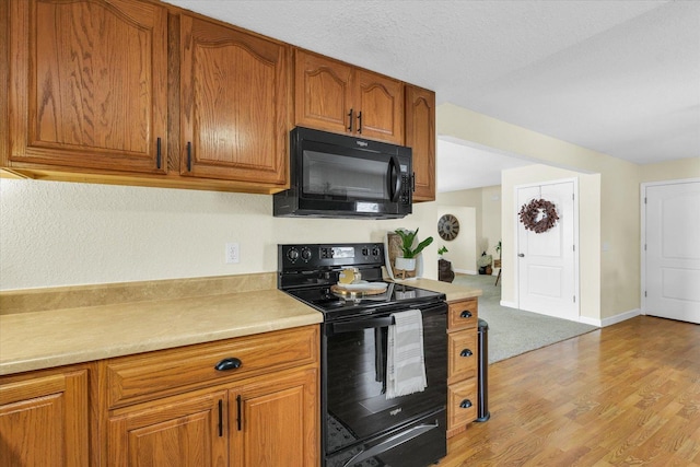 kitchen with black appliances and light hardwood / wood-style floors