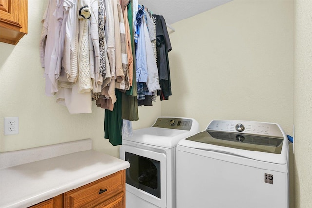 washroom with cabinets and washer and clothes dryer