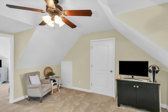 sitting room with vaulted ceiling, light colored carpet, and ceiling fan