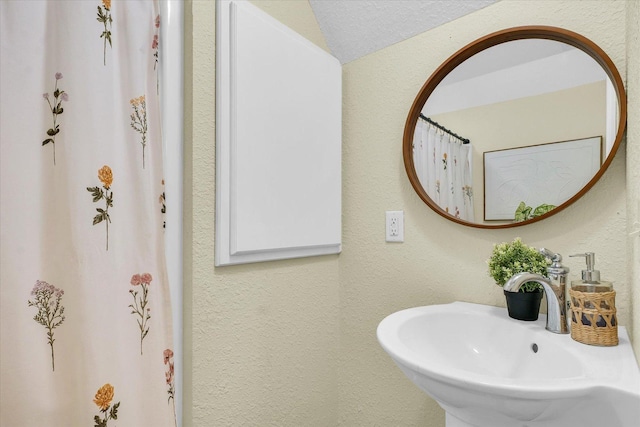 bathroom with lofted ceiling and sink