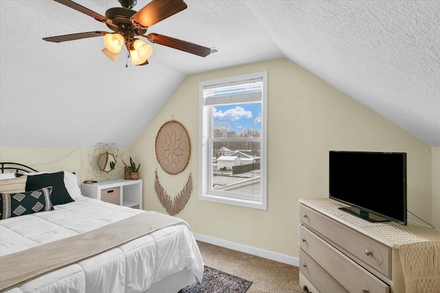 bedroom featuring a textured ceiling, vaulted ceiling, light colored carpet, and ceiling fan