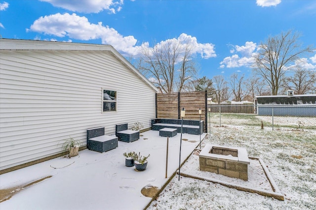 snow covered patio featuring a fire pit