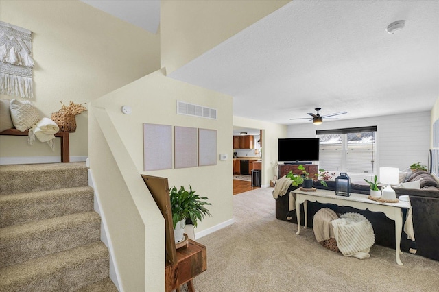 staircase featuring ceiling fan and carpet flooring