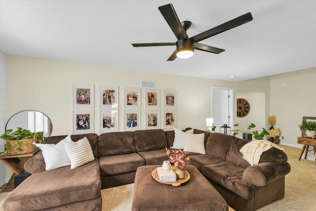 carpeted living room featuring a textured ceiling and ceiling fan