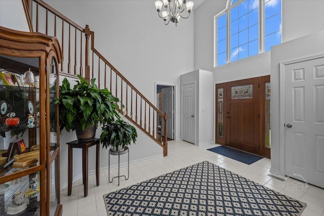 tiled entrance foyer with a high ceiling and a chandelier