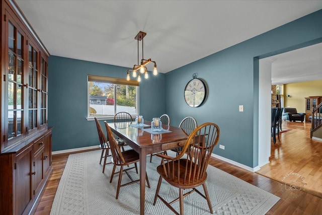 dining area featuring light hardwood / wood-style floors and an inviting chandelier