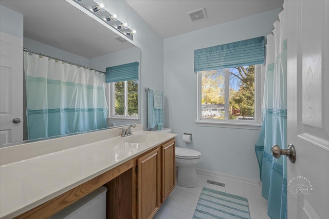 bathroom featuring toilet, vanity, and plenty of natural light