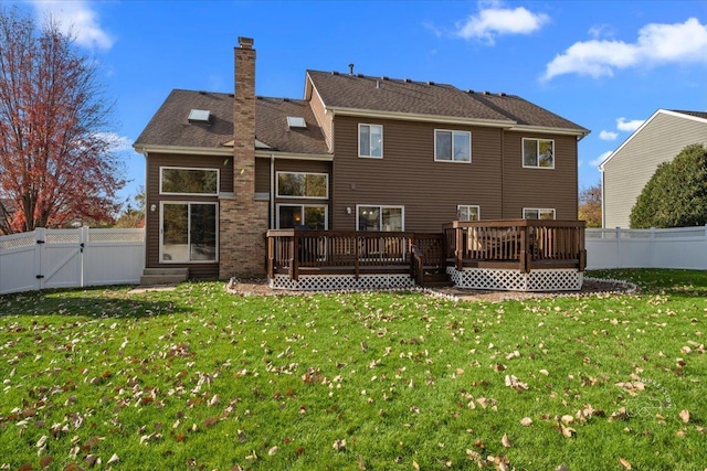 rear view of house featuring a yard and a wooden deck