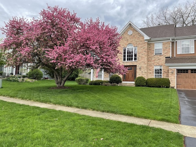 view of front of property featuring a front lawn and a garage