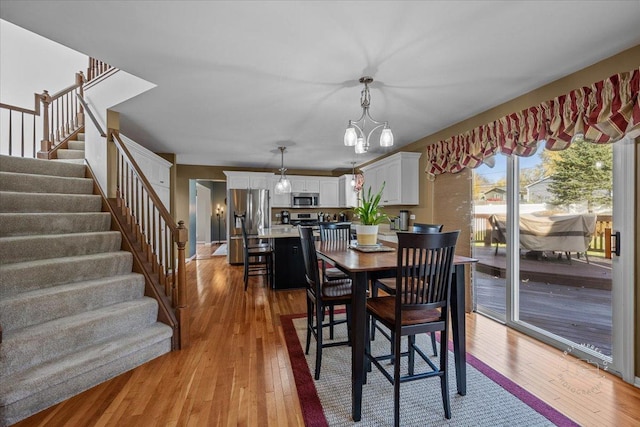 dining area featuring an inviting chandelier and light hardwood / wood-style flooring