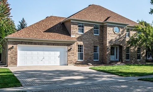 view of front of home with a garage and a front lawn